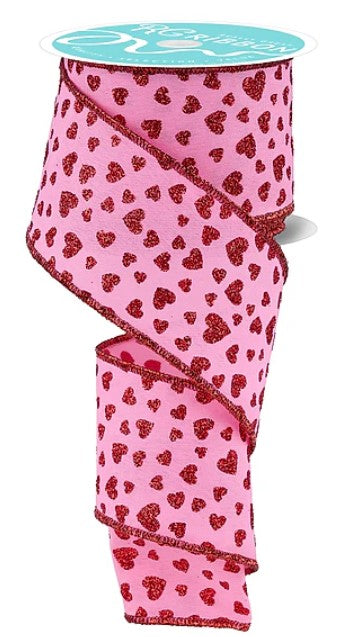 a pink ribbon with a pattern of red hearts on it.
