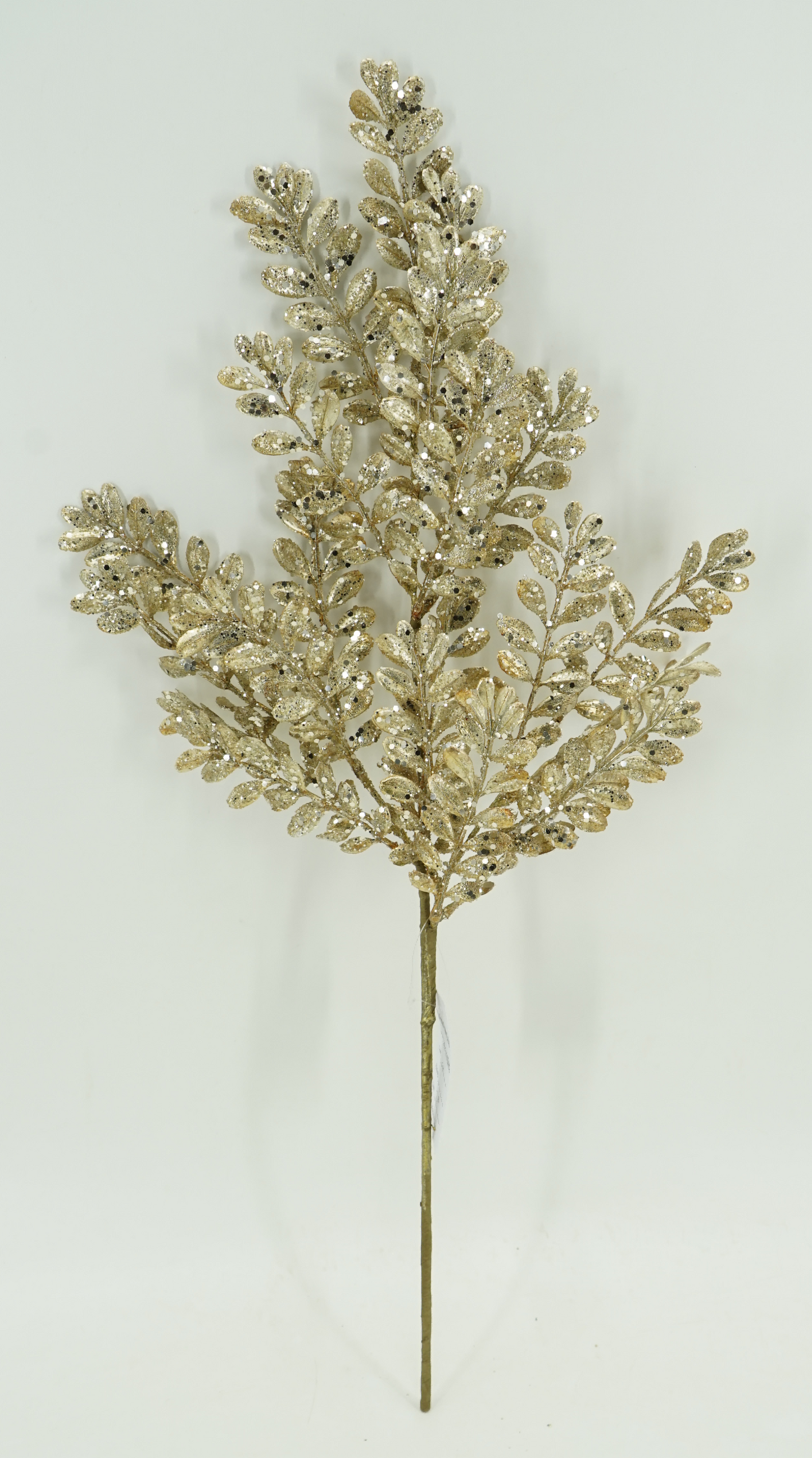 A gold leaf branch with intricate, sparkling leaves is displayed against a plain white background.