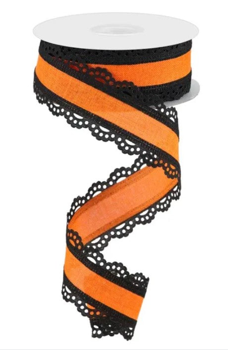 A spool of orange and black ribbon with a black lace-like pattern along the edges.