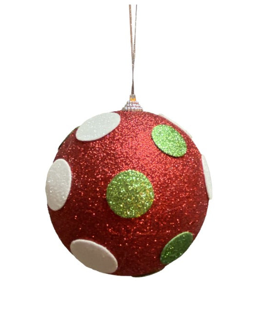 a red ornament with green and white dots