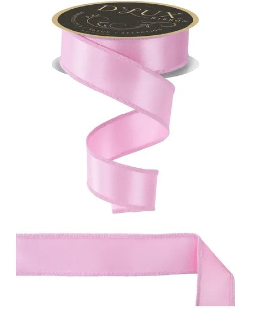 a pink satin ribbon with a black label, and a plain pink ribbon.