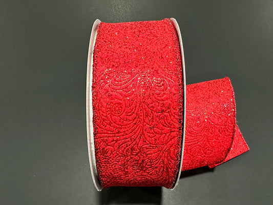 a roll of red glitter ribbon on a black surface