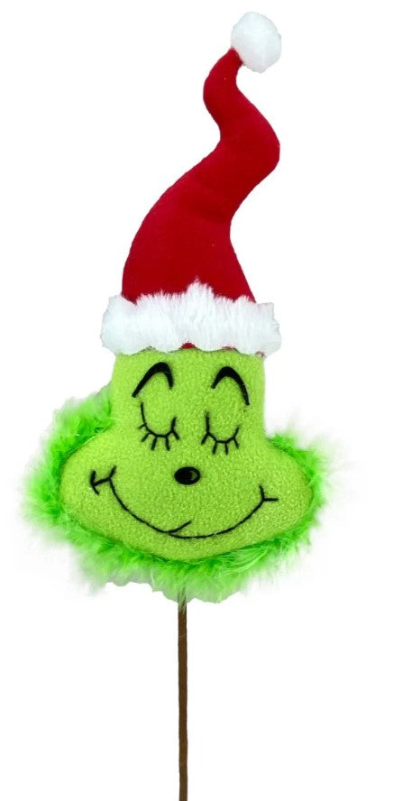 a green grin face with a santa hat on top of a stick