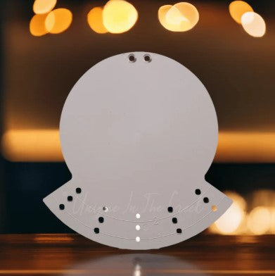 a white, circular object with a textured surface, placed on a wooden surface against a blurred background with warm, glowing lights.