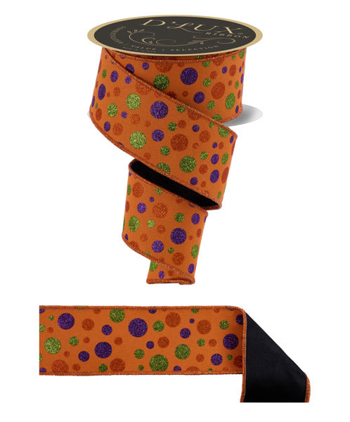 a spool of orange and green glittery ribbon with a pattern of orange and green circles.