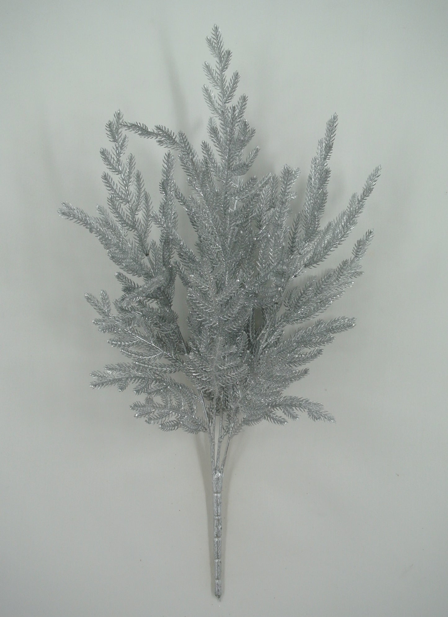 A silver-colored artificial plant or branch with multiple thin, pointed leaves arranged in a cluster.