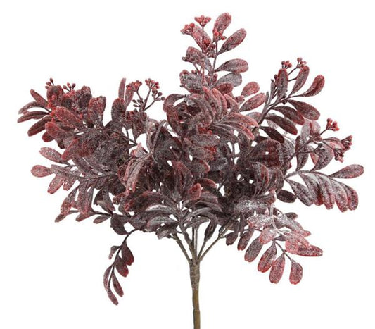 A close-up of a branch with red leaves and berries, possibly a fake plant or artificial decoration.