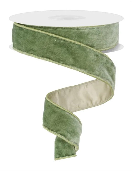 A roll of green velvet ribbon with a white backing.