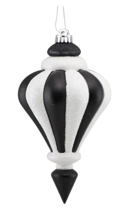 A black and white striped ornament with a pointed finial hanging against a white background.