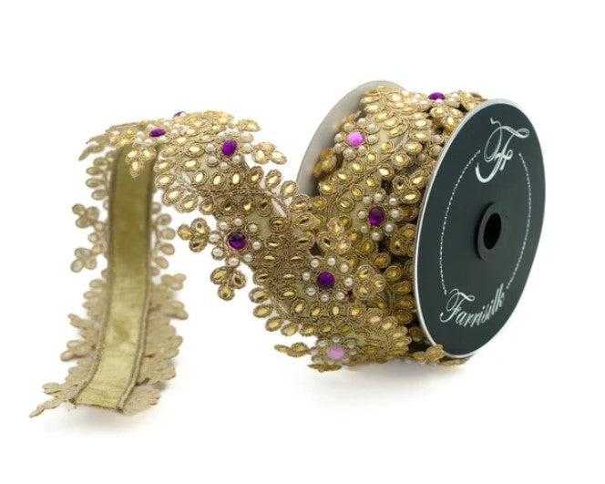 a gold-colored decorative ribbon with a floral pattern and small purple and white embellishments.