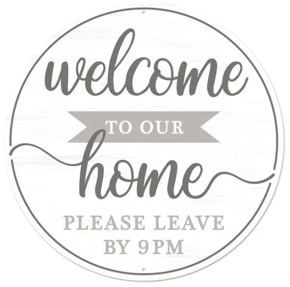 a circular sign with the text "welcome to our home" written in a cursive font. Below the main text, there is a smaller text that reads "PLEASE LEAVE BY 9PM".