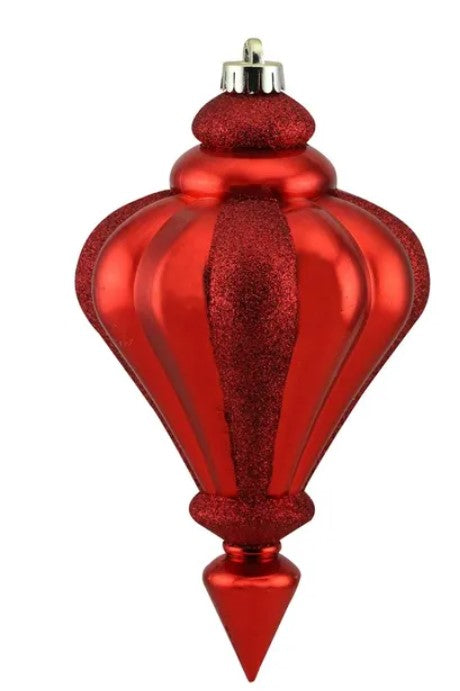 A red, shiny ornament with a pointed finial and a glittery texture.