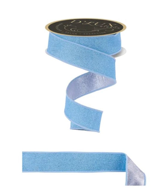 a blue ribbon with a silver glittery texture, and it is attached to a black circular label.