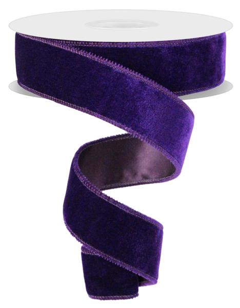 a roll of purple velvet ribbon on a white background