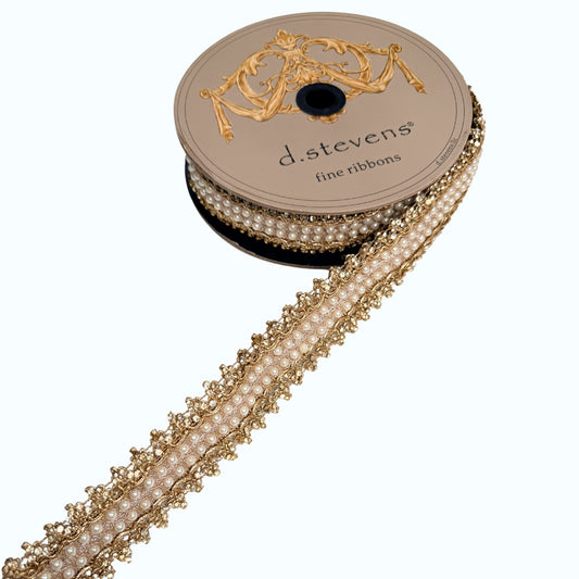 A spool of fine gold ribbon with a decorative trim, featuring a floral pattern.