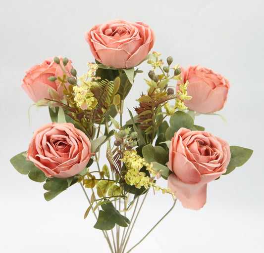 a vase filled with pink roses and greenery