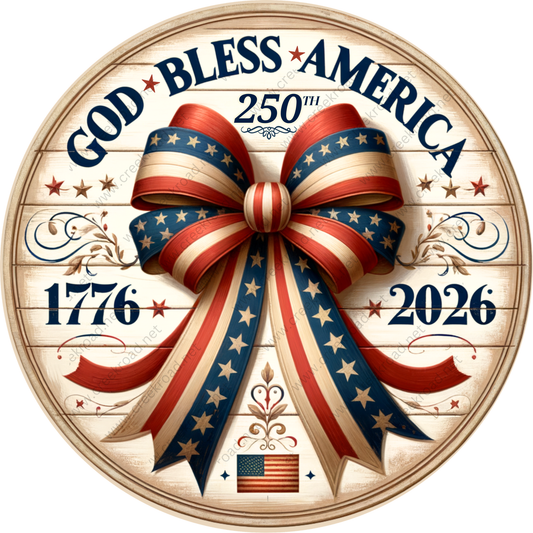 a circular design with a large bow made of red, white, and blue ribbons, surrounded by stars and the American flag. The text "God Bless America" is prominently displayed, along with the years "1776" and "2026" below the bow.