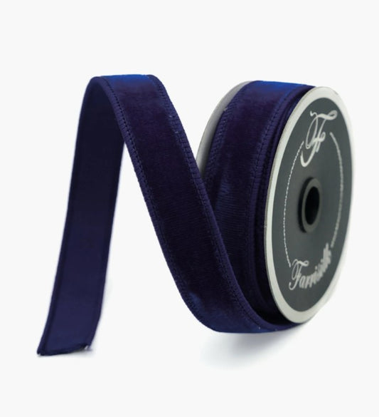 A roll of navy blue velvet ribbon with a silver logo on it.