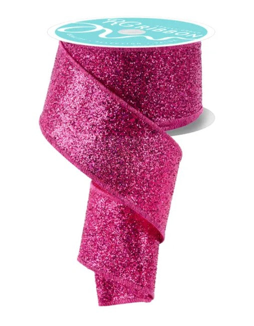 A roll of pink glittery ribbon with a turquoise label.