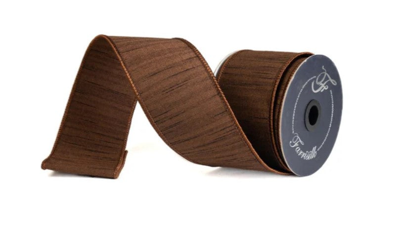 A roll of brown fabric ribbon with a silver logo on it.