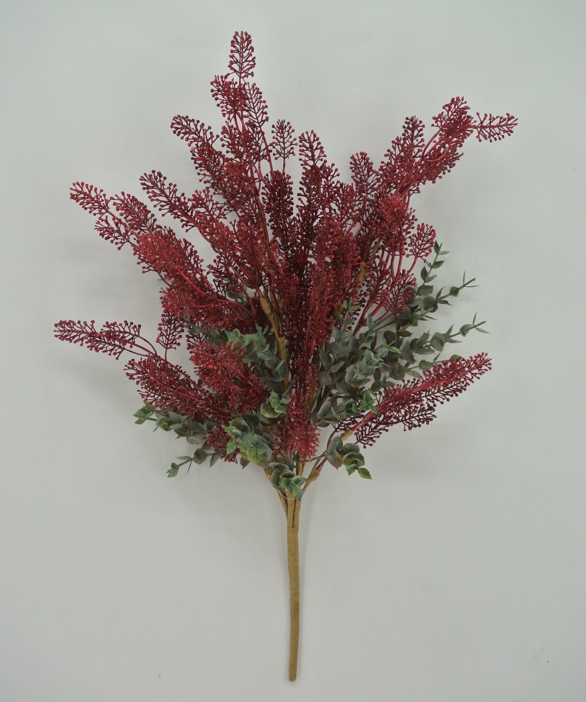 A bouquet of red and green flowers is displayed against a white background.
