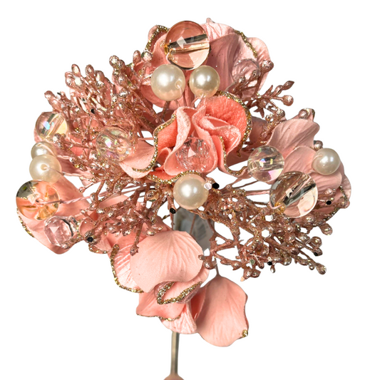 A bouquet of pink flowers adorned with pearls and crystals, creating a visually appealing and elegant arrangement.