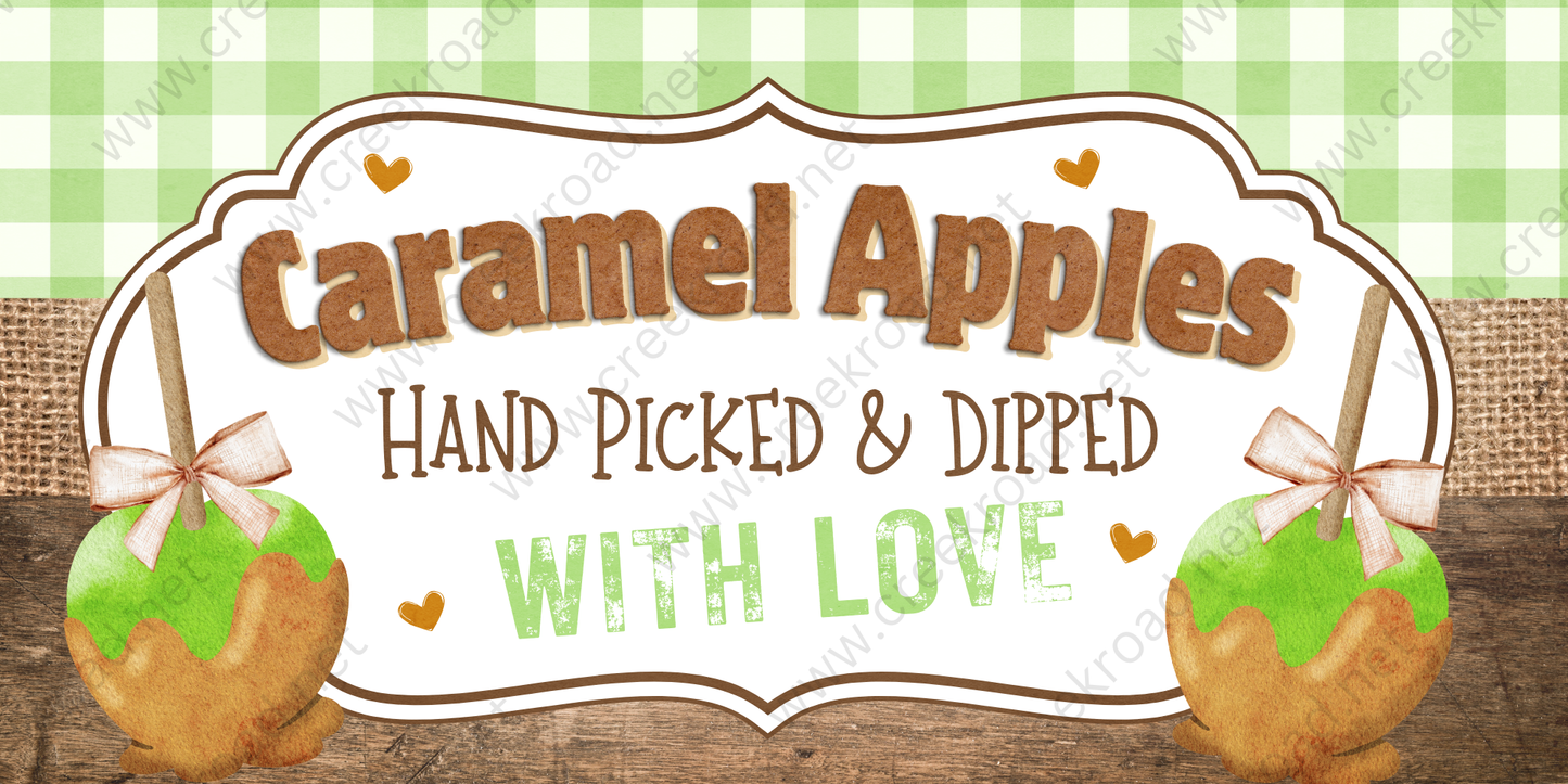 a sign for "Caramel Apples" that reads "Hand Picked & Dipped with Love". The sign is set against a green and white checkered background, and there are two caramel apples on either side of the sign, each with a bow on top.