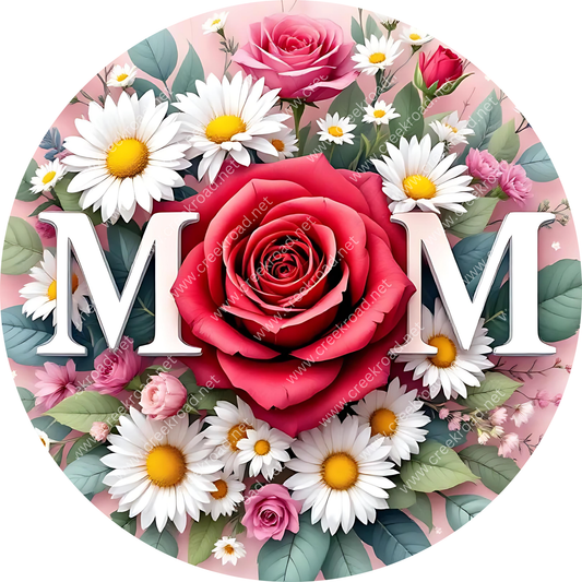 A circular arrangement of flowers, including roses, daisies, and other blooms, with the word "MOM" prominently displayed in the center.