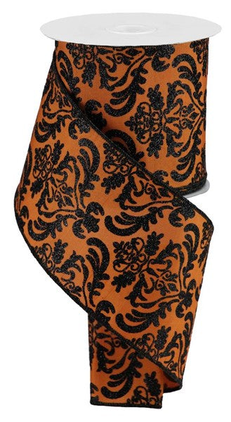 a roll of orange and black damask ribbon with a repeating floral pattern.