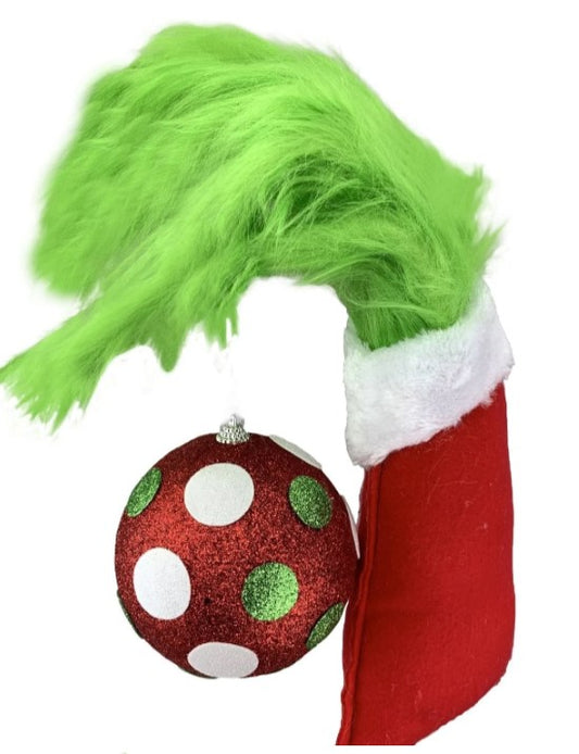 a grinly christmas ornament hanging from a red stocking