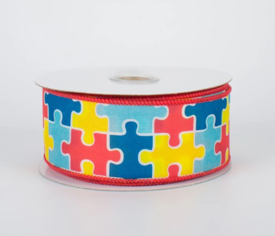 A roll of ribbon with a colorful puzzle piece pattern on it.